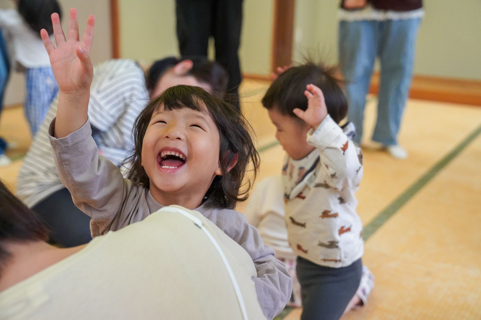 手を上げて大笑いする女の子