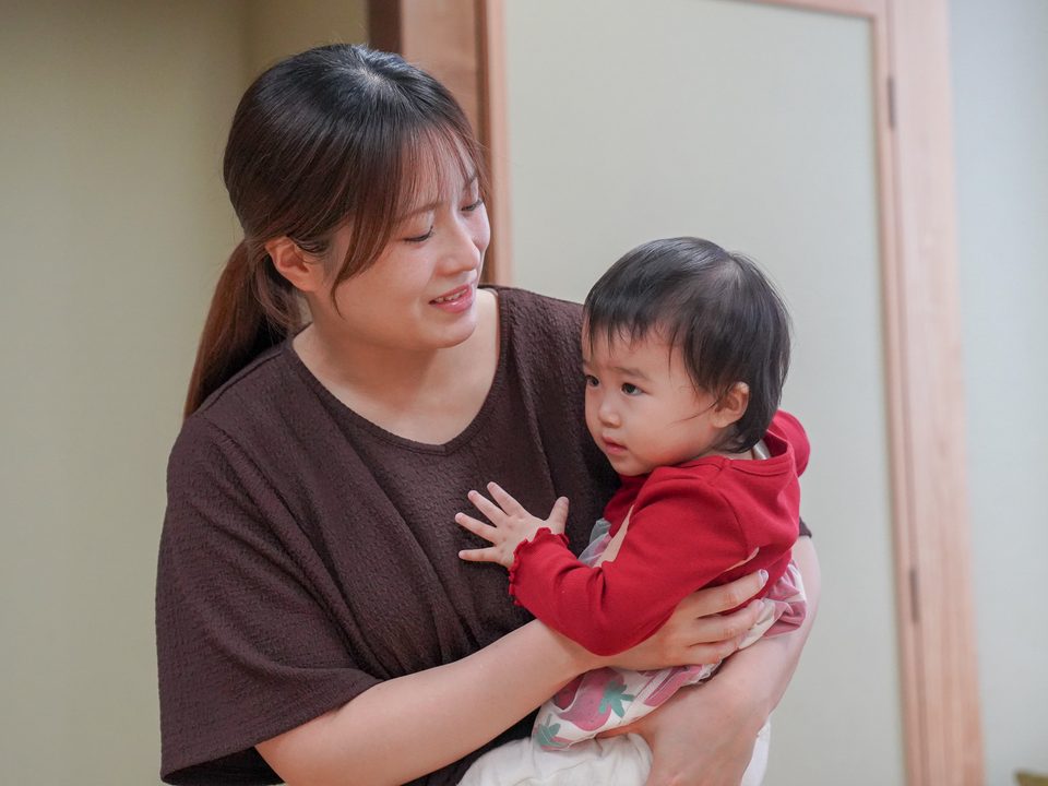 赤ちゃんを抱っこして、にっこり見つめるママ