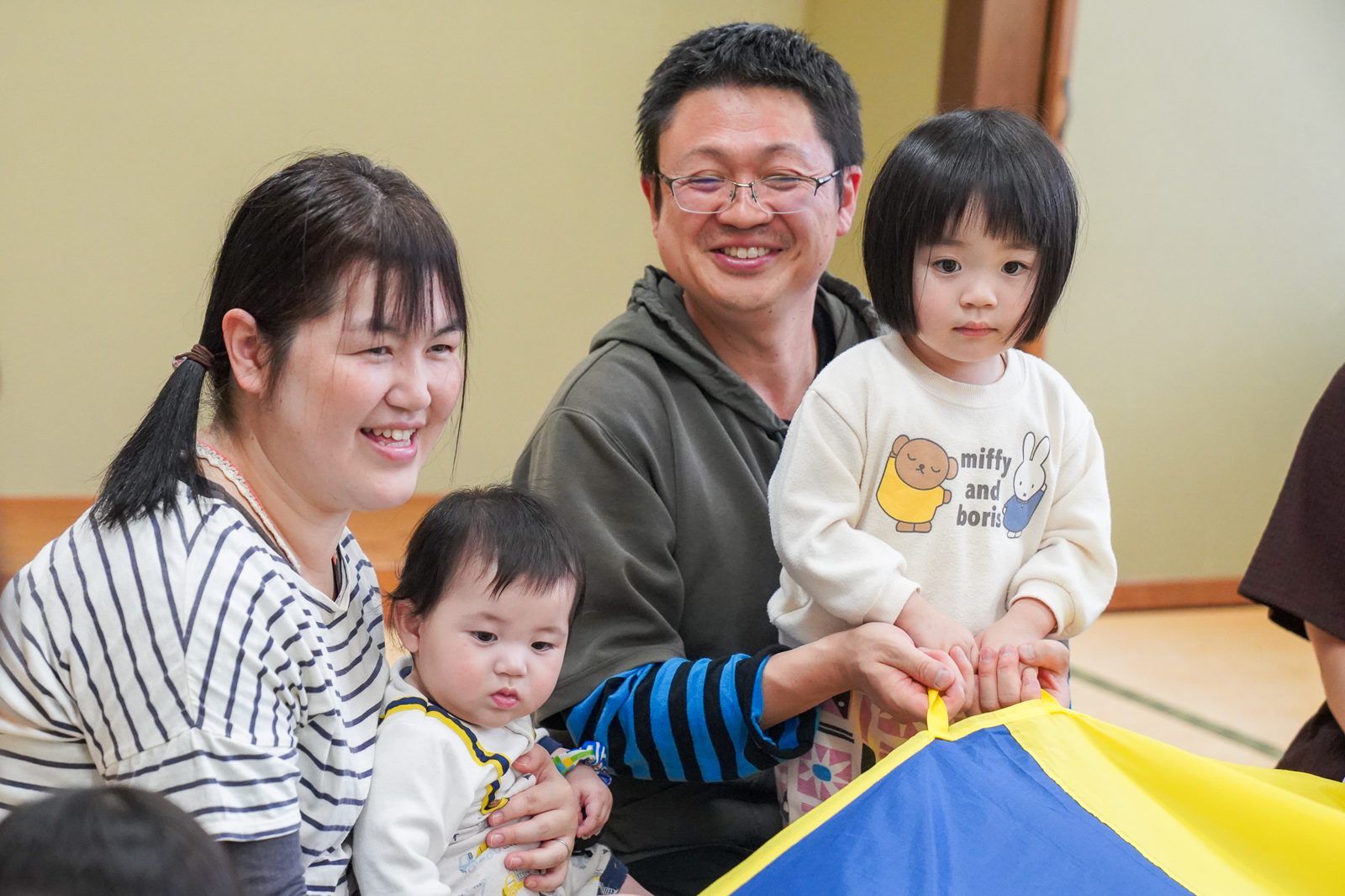 パパとママ、きょうだいで一緒にパラバルーンを持つ家族