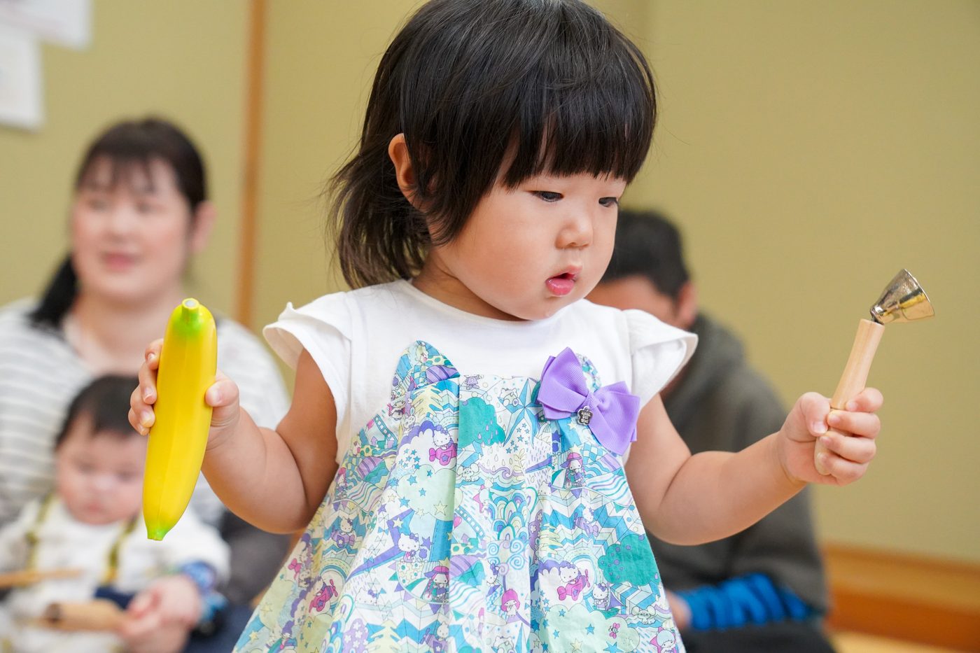 楽器を両手に持って音を聞く女の子