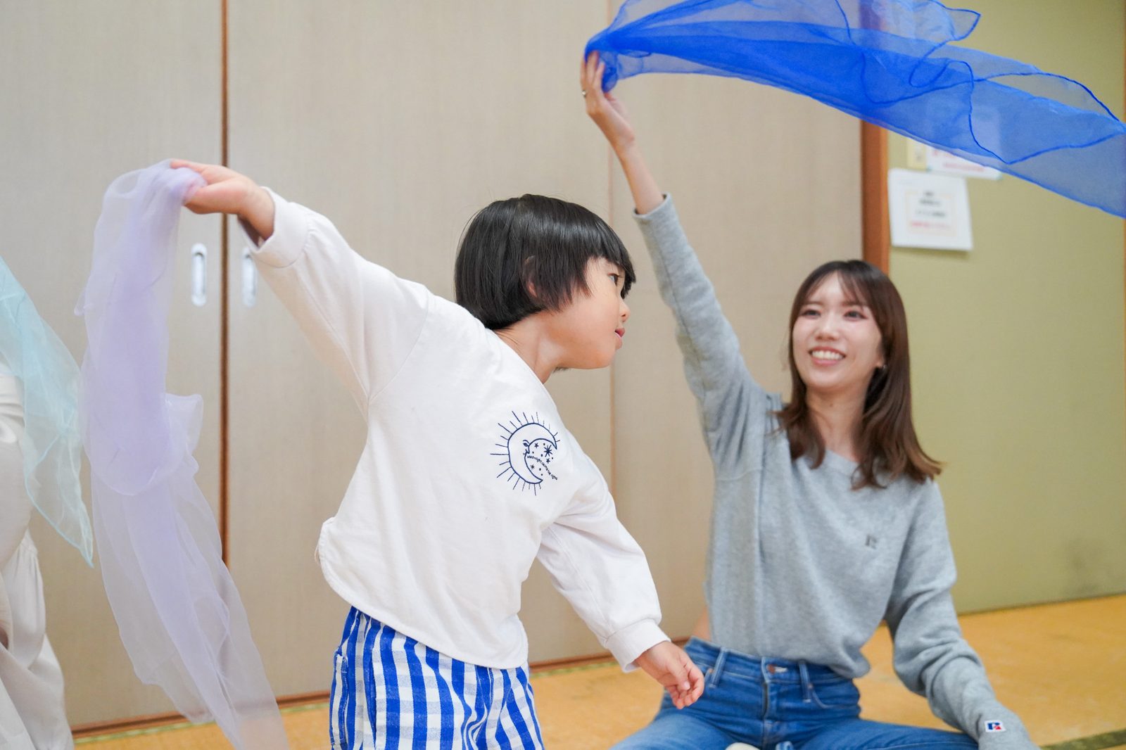 スカーフを振って、ママと一緒に踊る男の子