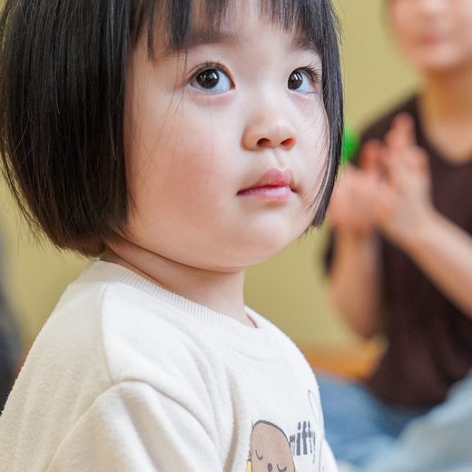 先生の方を見上げる女の子